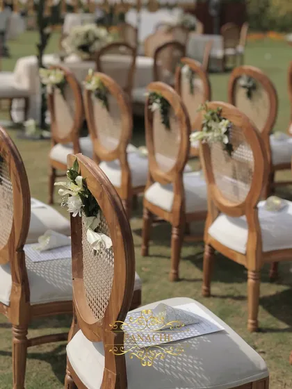 A detail of the elegant guest chairs, adorned with a small posy of white flowers.
