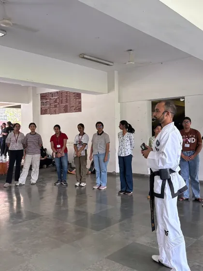 As an instructor, my role is to create a space of focus and learning. This moment from our workshop at Lady Shri Ram College shows me guiding participants through the principles of situational awareness and body language.