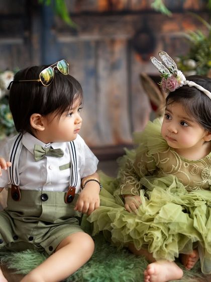 A candid moment between two babies during a rustic-themed shoot. Their curious expressions and interaction are what make these photos so special.