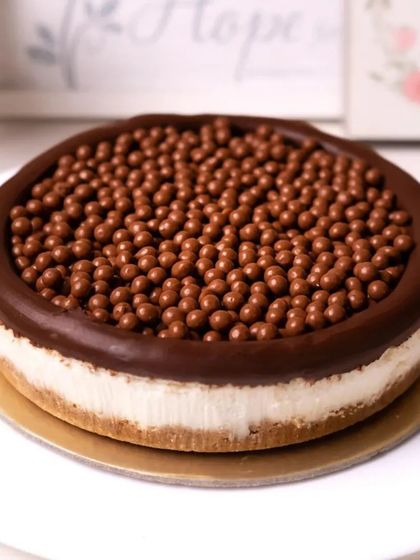 A crunchy and creamy cheesecake topped with a layer of chocolate and crispy chocolate balls.