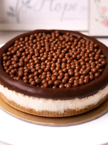 Another view of the Maltesers Cheesecake, showcasing the crunchy chocolate balls covering the entire top. It's a textural delight and a feast for the eyes.