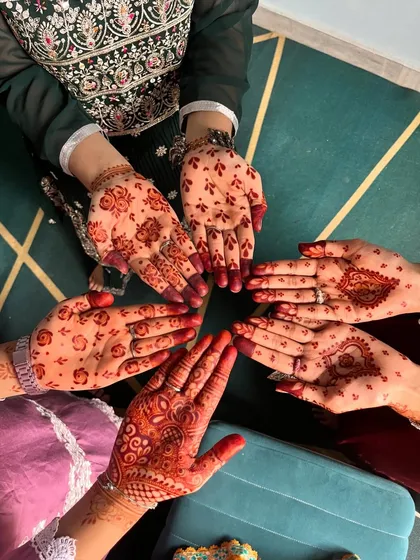 A group of friends showing off their festive henna stains, each with a unique, simple design.