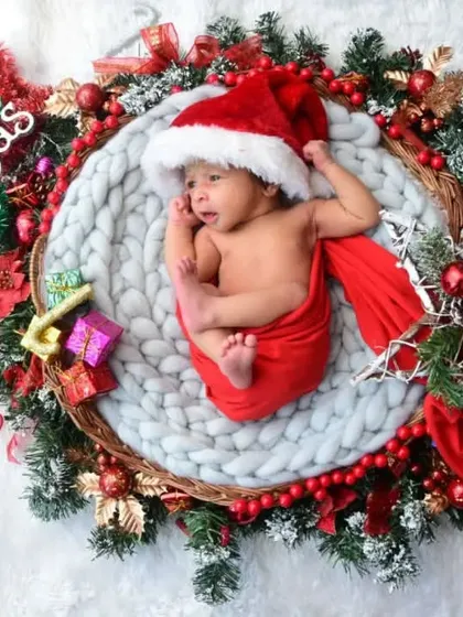 A Merry Christmas baby! This newborn is nestled in a festive wreath, making for a perfect holiday announcement.