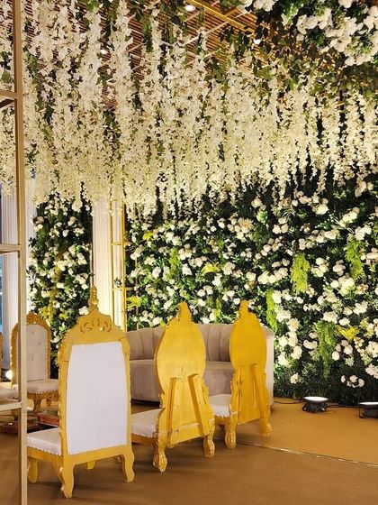 Another perspective of the green floral stage, showcasing the intricate details of the golden pillars and the floral arrangements.