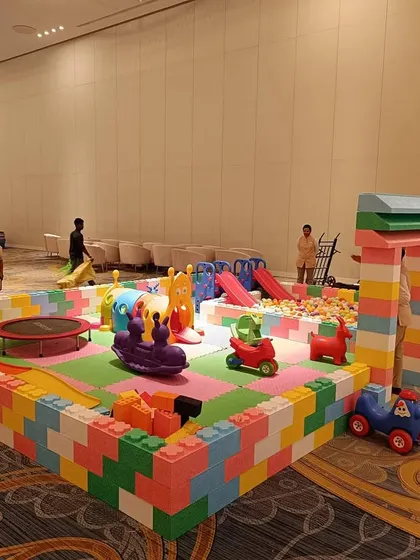 Another angle of our large play area, highlighting the different components like the mini trampoline, train rider, and various small cars. The modular design allows us to fit different venue sizes and shapes.