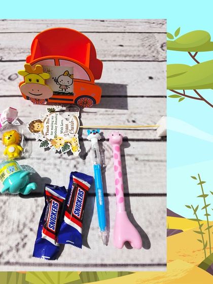 An unwrapped view of the jungle pen stand hamper, showing the car-shaped holder, giraffe pen, animal erasers, and Snickers bars.