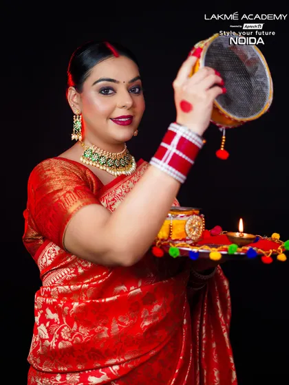 A happy and festive portrait. This look, with a classic red Banarasi saree and traditional jewelry, is a perfect example of the event-specific makeup our students learn.