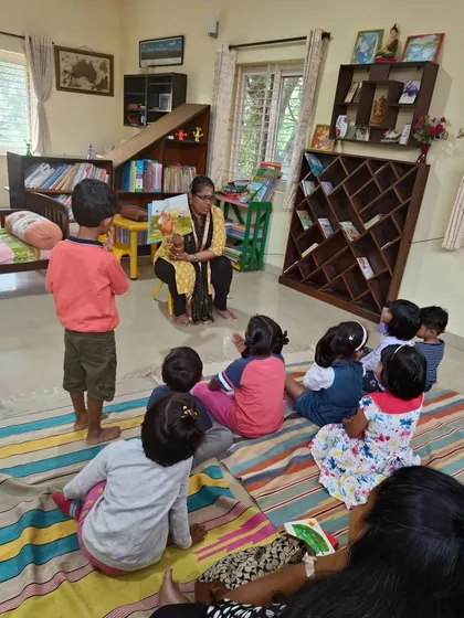 The storyteller shows a picture of Hettie with birds in her hair, causing amusement among the children.