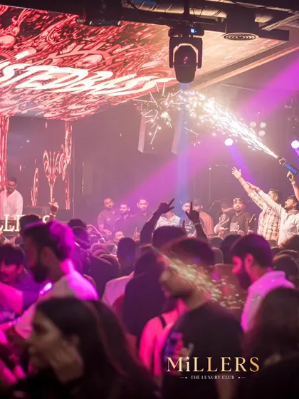A wide shot of the party at Millers, Pune. You can see the packed dance floor, the pyro guns going off, and the incredible lighting that makes for an epic night.