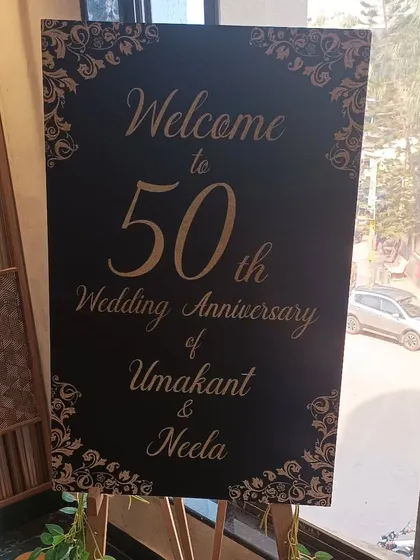 A classic black and gold welcome sign for the 50th wedding anniversary of Umakant and Neela.