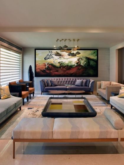 A full view of the pastel-toned living room, where different shades of blue, lavender, and beige come together. The large artwork and unique coffee table anchor the space, creating an oasis of calm in the city.