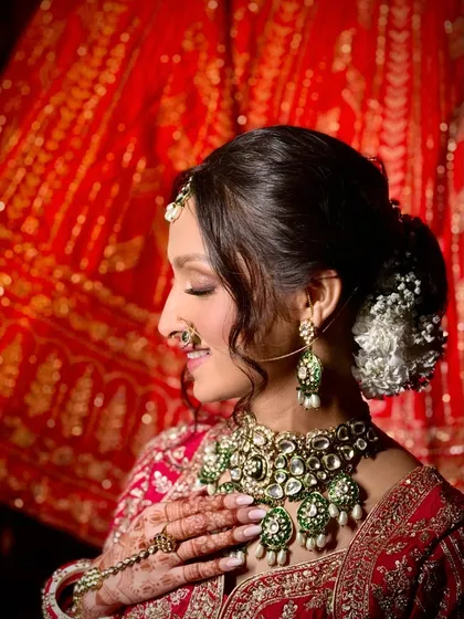 A side profile showcasing the soft contouring and the elegant floral hair bun. Every detail is considered to create a harmonious and beautiful bridal look.