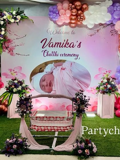 A modern take on a Chhathi or Thottil ceremony, using a personalized photo backdrop and a beautiful arrangement of pastel and metallic balloons to frame the cradle.