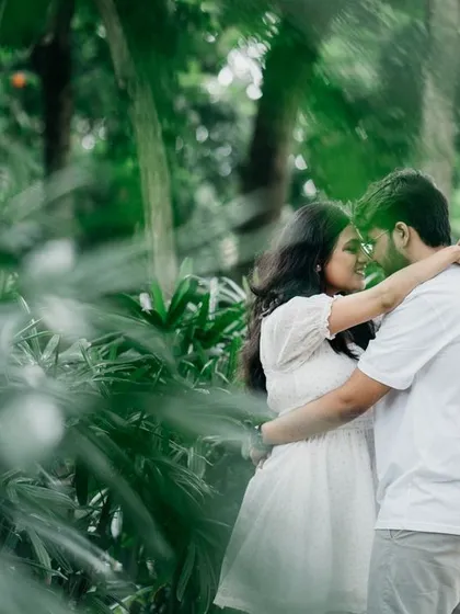 Framed by palm leaves, this image captures an intimate embrace. Using natural elements for framing adds depth and a sense of privacy to your pre-wedding photos.