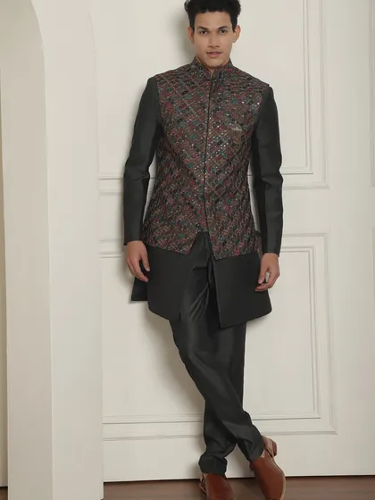 This charcoal-colored kurta-bundi set makes you stand out at any sangeet or mehndi night. The multi-colored embroidery on the jacket is effortless yet high on style.