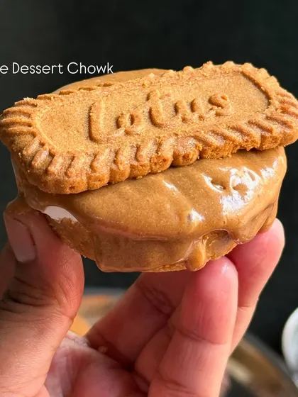 A close-up of a mini Lotus Biscoff cheesecake. It's a creamy cheesecake base topped with Biscoff spread and a signature biscuit.