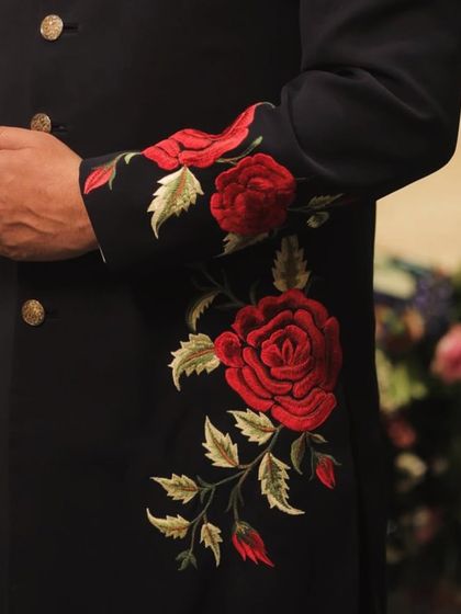 Another detailed look at the hand-embroidered sleeve. The texture and color of the threadwork stand out beautifully against the deep navy fabric.