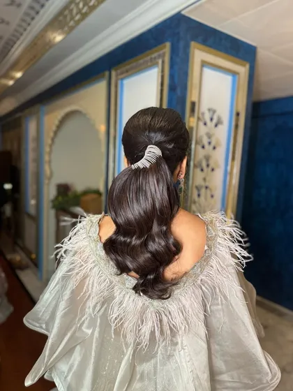 A back view of the stunning wavy ponytail, showing the beautiful volume and the elegant accessory that completes the look.