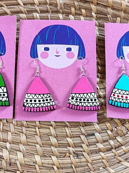 These triangular earrings feature a simple, modern tribal pattern. They are lightweight and come in bright colors like green, pink, and blue.