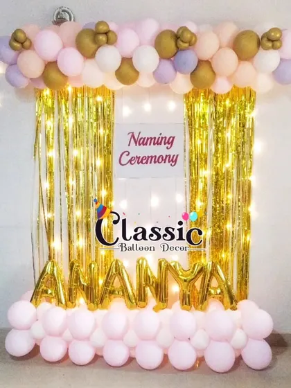 A simple and sparkly naming ceremony backdrop. We used a golden foil curtain, fairy lights, and foil letter balloons to spell out the baby's name.