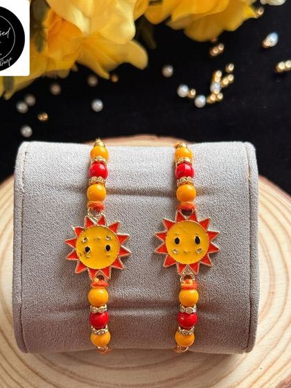 A cheerful sunshine rakhi to brighten up their day. This happy sun charm on a colorful beaded thread is perfect for your little ray of sunshine.