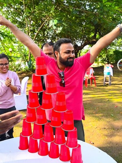 A triumphant moment for a team after successfully completing a cup pyramid challenge. These timed activities are great for fostering communication and a little friendly competition among colleagues.