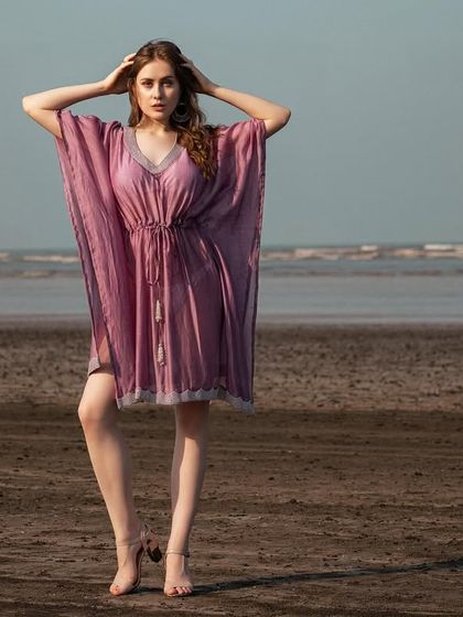 A full-frontal view of the purple kaftan, showcasing its relaxed and comfortable fit for a beach setting.