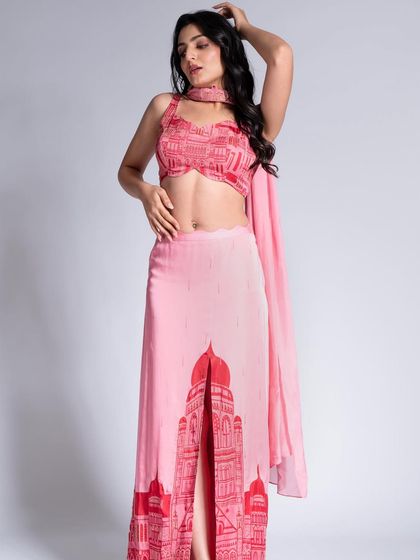 A contemporary ethnic look featuring a printed skirt and crop top. The makeup is kept soft and pretty, with loose waves in the hair for a relaxed feel.