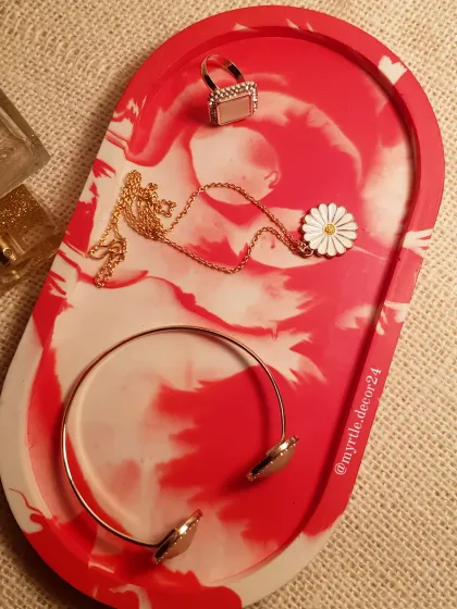 An extra-large oval trinket tray with a striking red and white marble pattern. It's spacious enough to hold multiple accessories, making it both a functional and beautiful addition to your decor.