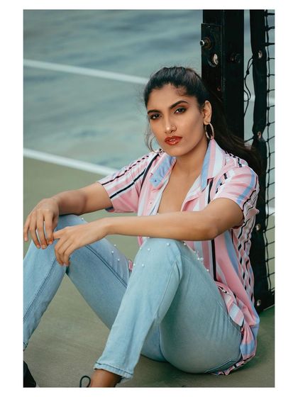 A seated pose from the same outdoor shoot, offering a different perspective on this casual look.