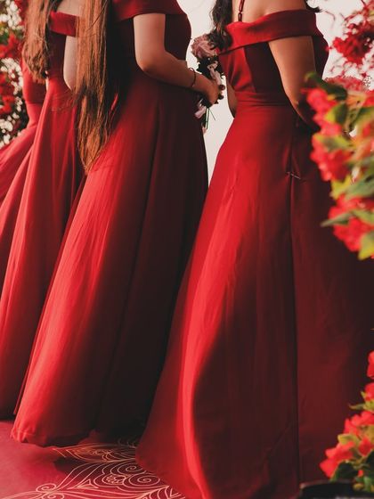 The bridesmaids in elegant red gowns, standing by a floral arch of matching red blooms. The color theme was carried through every element of the decor to create a cohesive and visually stunning wedding.