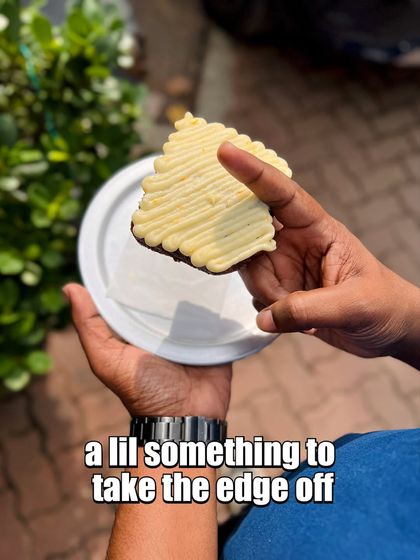 A slice of cake with perfectly piped frosting, held up as the ideal pick-me-up.