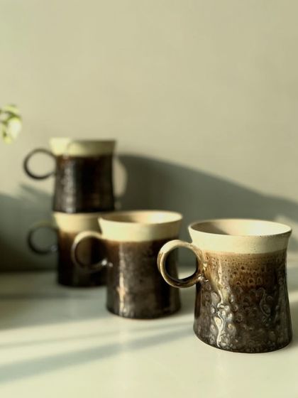 A family of metallic mugs from our Shibui Collection, each with slight variations that speak to their handmade origin.