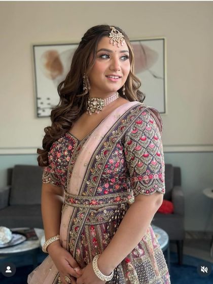 A beautiful client ready for an event. Her hair is styled in a half-updo with voluminous curls, a classic look that is always in style.