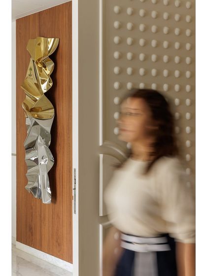 An artistic shot capturing my sculpture next to the apartment's textured main door, a space where art and design meet.