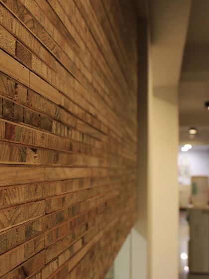 A detail of a partition wall in the White Canvas office. We repurposed waste blockboard from the site to create this textured surface, adding a sustainable and tactile element to the design.