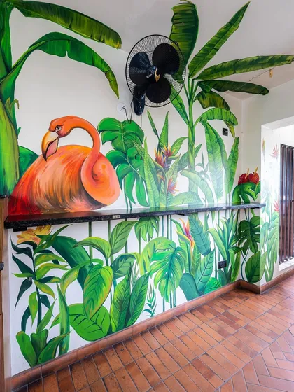 We love incorporating bold, hand-painted murals into our designs. This vibrant flamingo and tropical leaf artwork adds a playful and artistic touch to the wall, turning it into a feature.