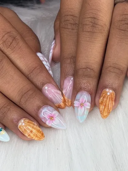 A close-up that captures the texture of the seashell nail and the delicate petals of the 3D flower.