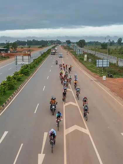 An aerial shot of the peloton on a multi-lane highway, showcasing the impressive infrastructure of our race routes.