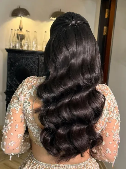 A back view of a half-ponytail with stunning, glossy Hollywood waves, perfect for a glamorous evening event.
