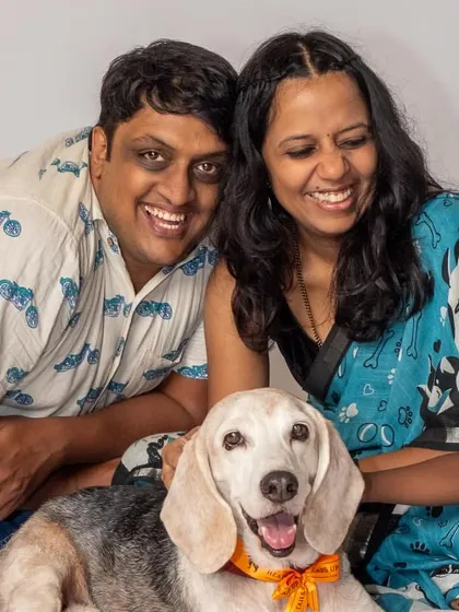 A happy family portrait with their son and their beloved beagle, Seenu. This studio shot captures the joy and connection of the whole family.