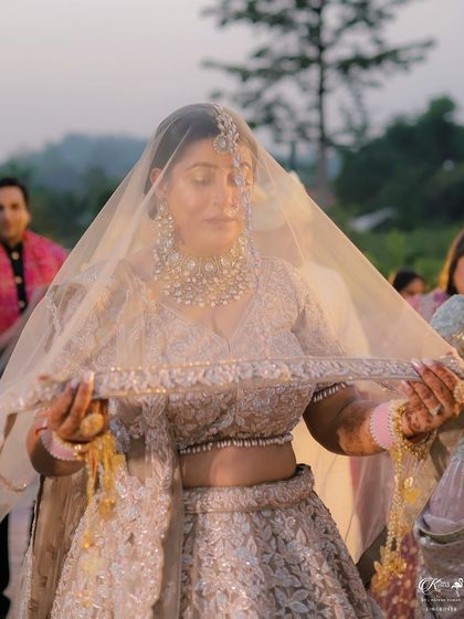 A close-up of the bride under her veil as she walks towards the mandap.