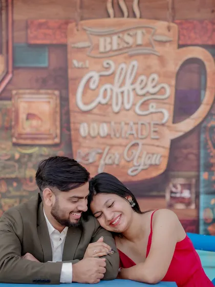 A cozy and romantic moment at a cafe-themed set. The couple's intimate pose and the charming background create a sweet, story-driven image perfect for their pre-wedding album.