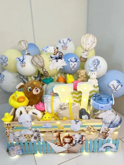 This baby boy hamper is an explosion of fun. It's a diaper cake style arrangement in a pinewood crate, decorated with balloons, toys, and light-up initials.