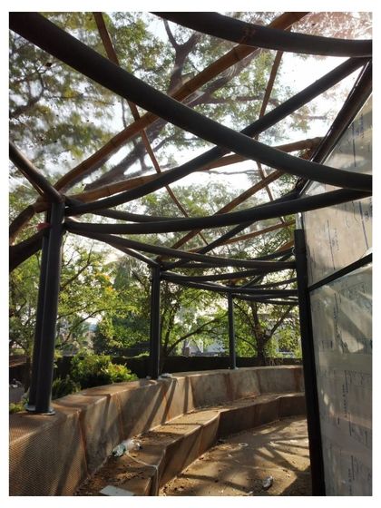The roof structure of the Koodaaram Pavilion under construction, showcasing the intricate weaving of bamboo and the underlying steel frame.