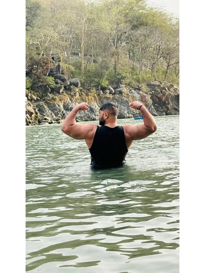 Showing my back development while standing in the river. Strength built in the gym, displayed in nature.