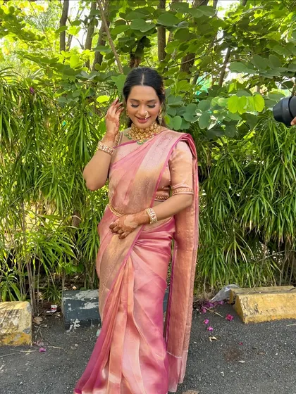 A beautiful full-length shot of Isha in her stunning pink Kanjivaram saree. The makeup is classic and minimal, letting the richness of her outfit shine.