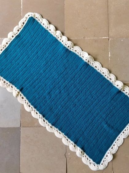 A rectangular table runner in teal and cream.