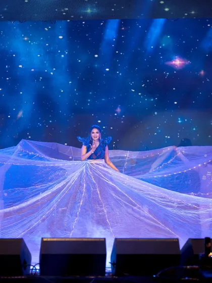 A bride looking like a celestial dream. For this solo, we used a massive, flowing prop with fairy lights to create a magical, starry-night effect, making her performance truly out of this world.