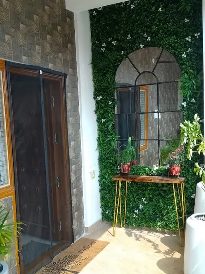 The entrance to your home should feel welcoming. Here, I used a beautiful arch-shaped mirror against a lush green wall to make the space feel bigger and brighter. A couple of simple white planters complete the fresh, clean look.